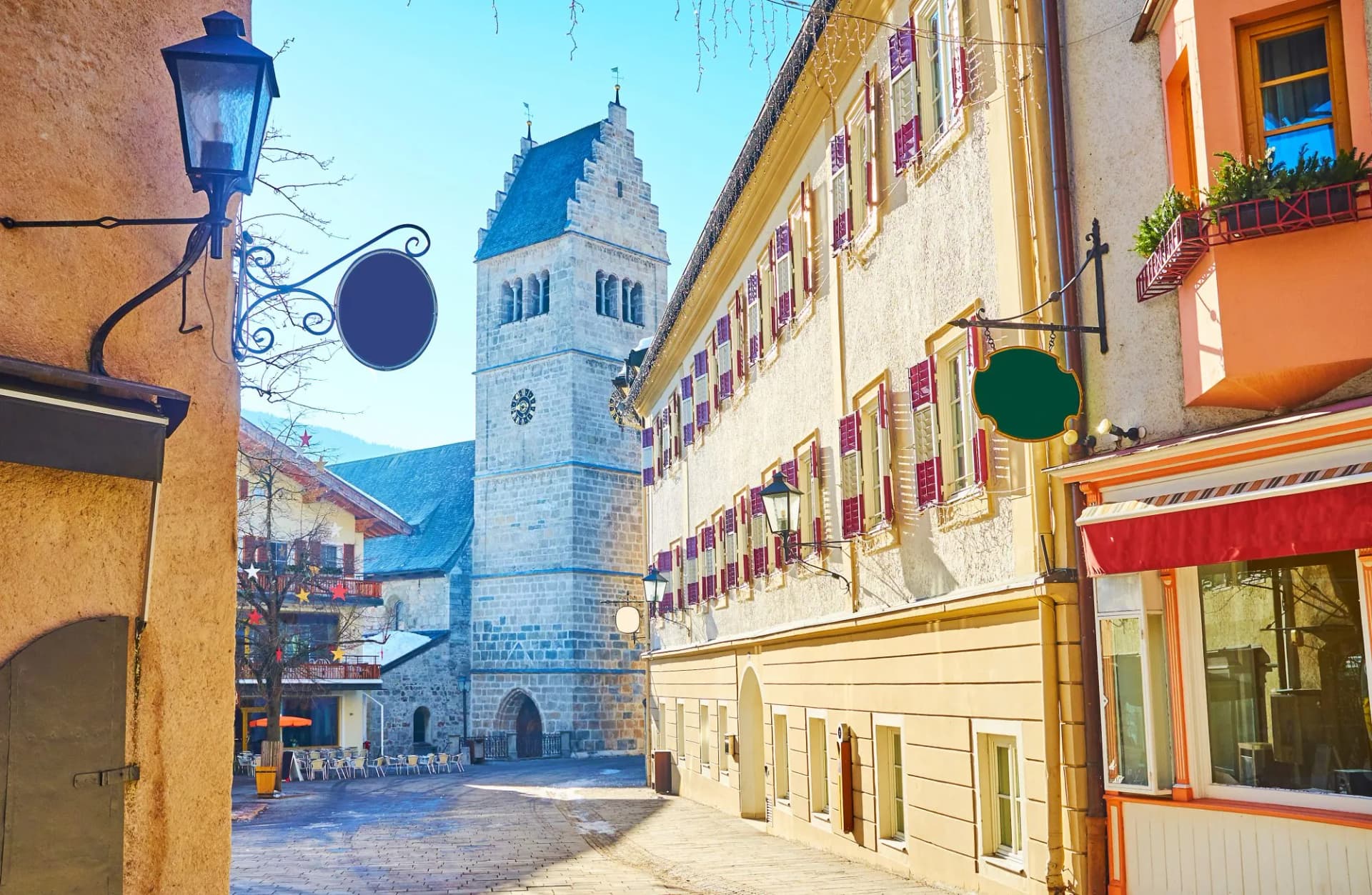Cobblestone square in Zell am See with stone church tower and traditional buildings