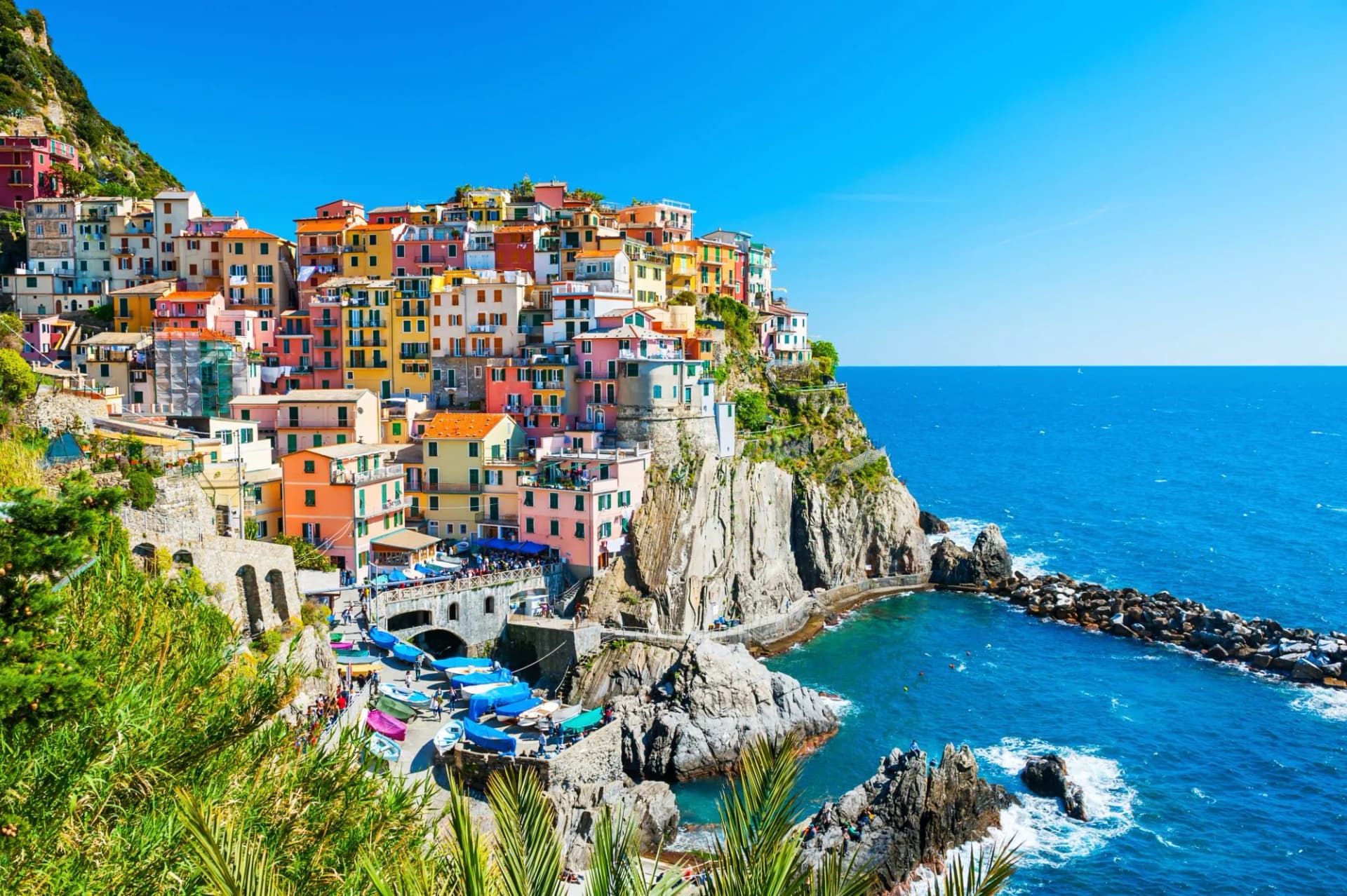 Colorful cliffside village houses overlooking bright blue Mediterranean Sea in Cinque Terre National Park, Italy.