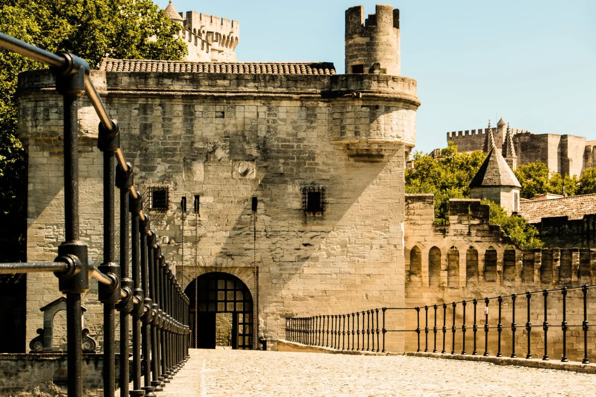 Stone rampart entrance and drawbridge railing leading to the Pont d'Avignon.