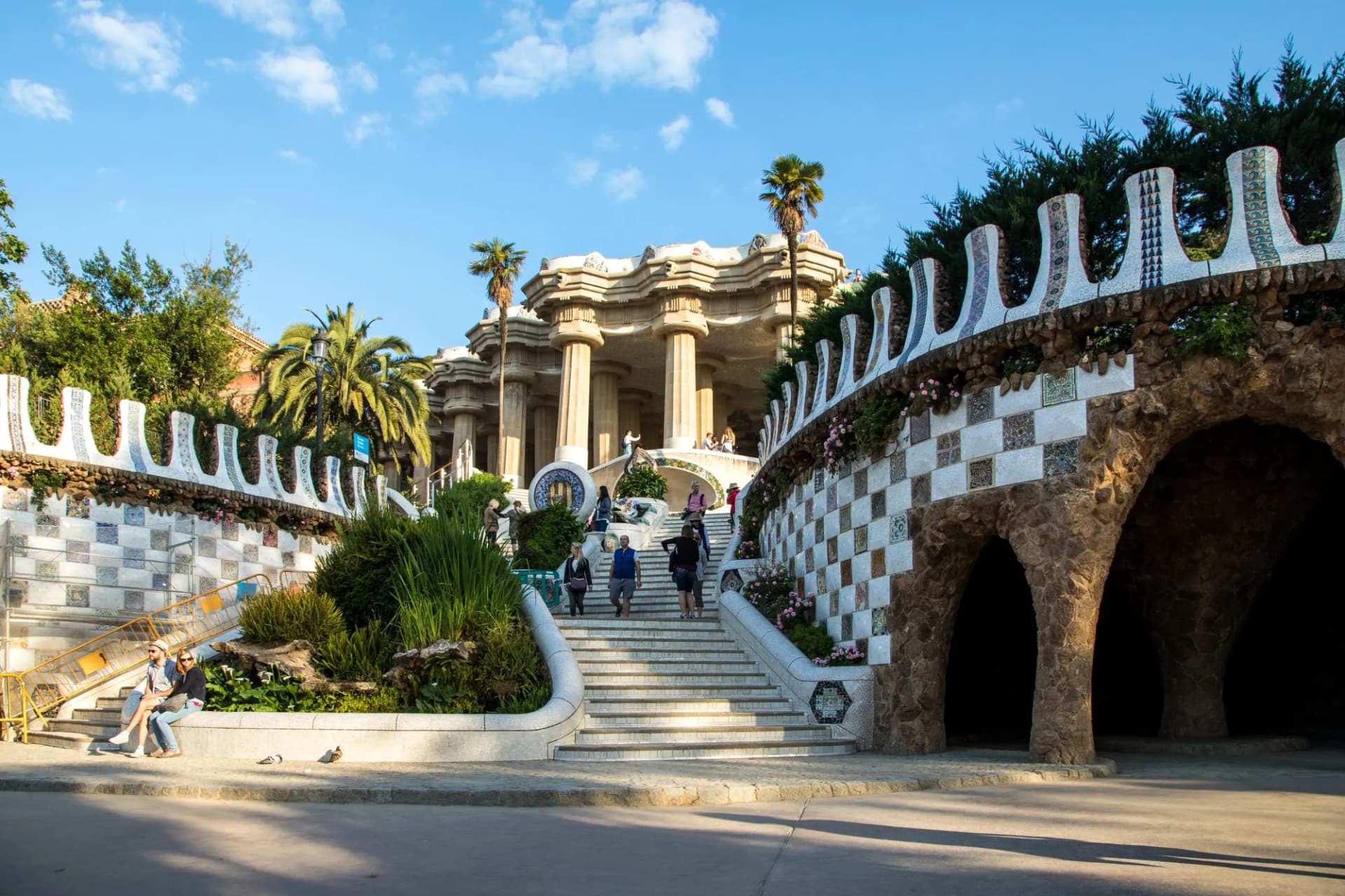 Stairway at Parc Güell in Barcelona with mosaic walls and Doric columns.
