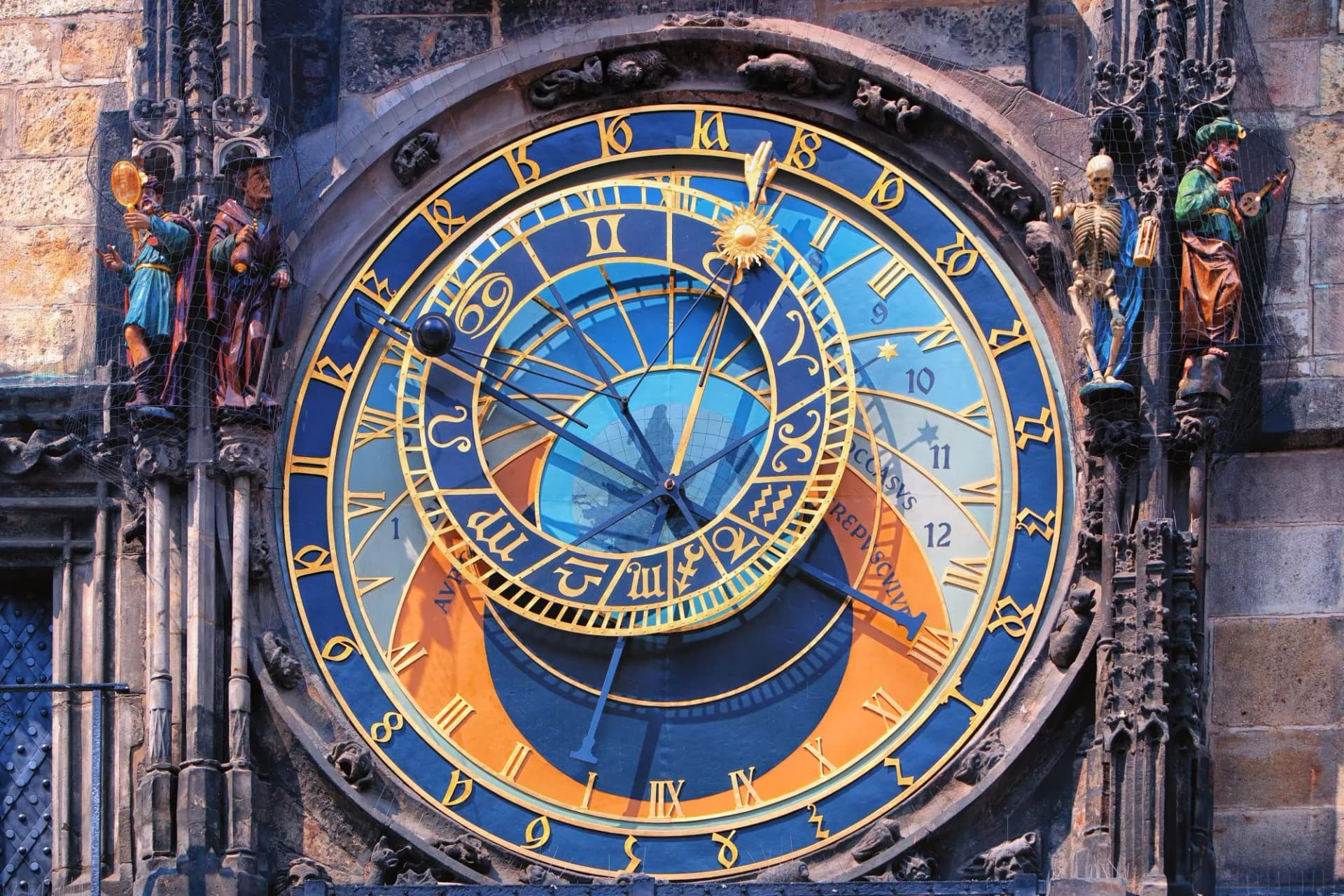 Prague Astronomical Clock face with zodiac signs and surrounding carved figures.