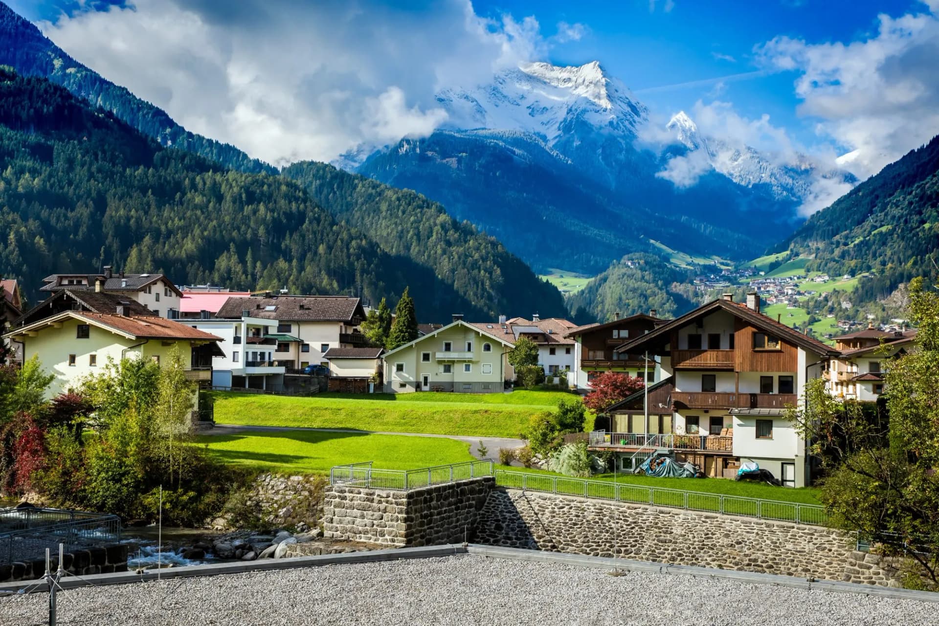 Alpine village in Mayrhofen, Austria with autumn foliage and snow-capped mountains.