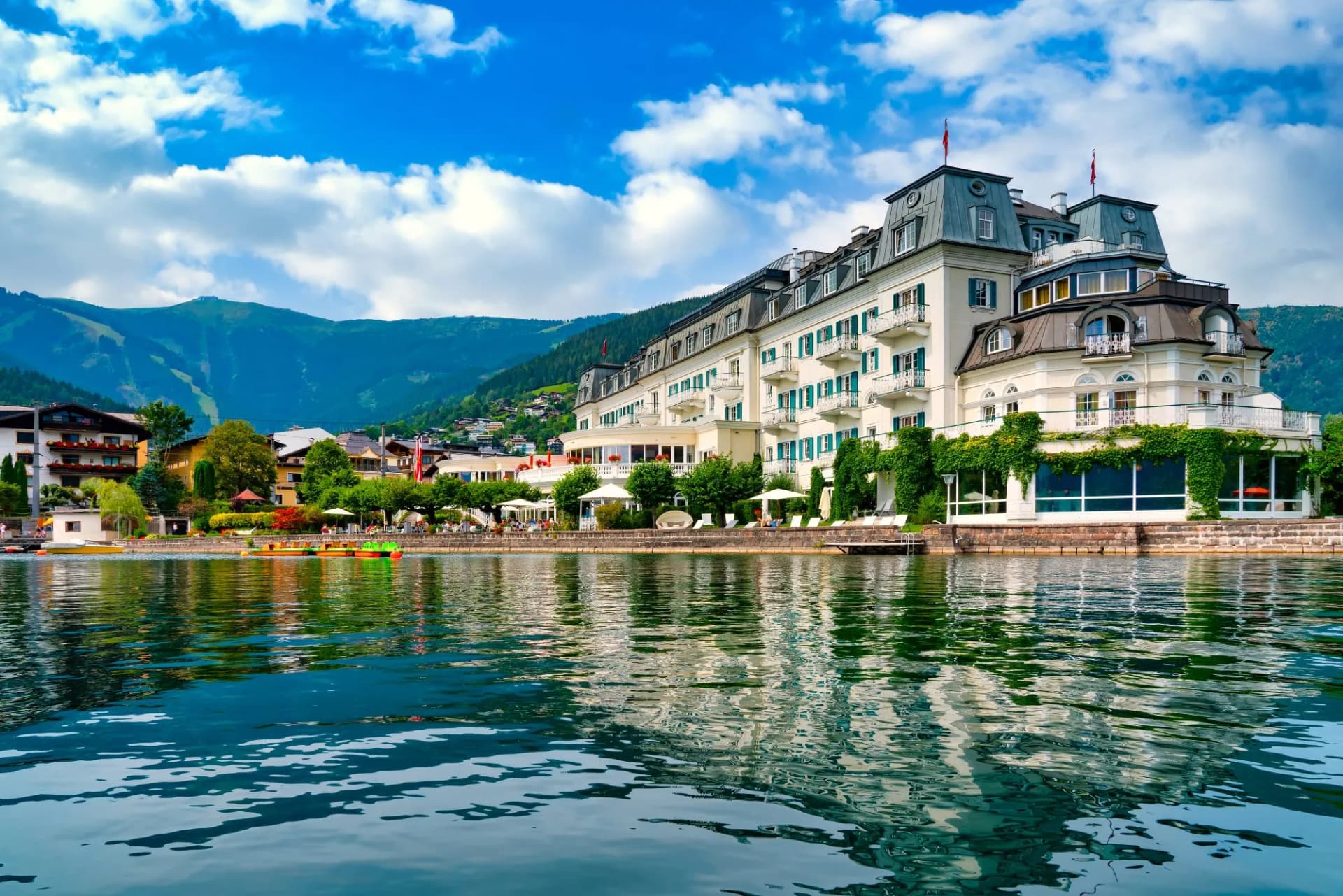 Grand hotel on Zell am See lake promenade with mountains in Austria