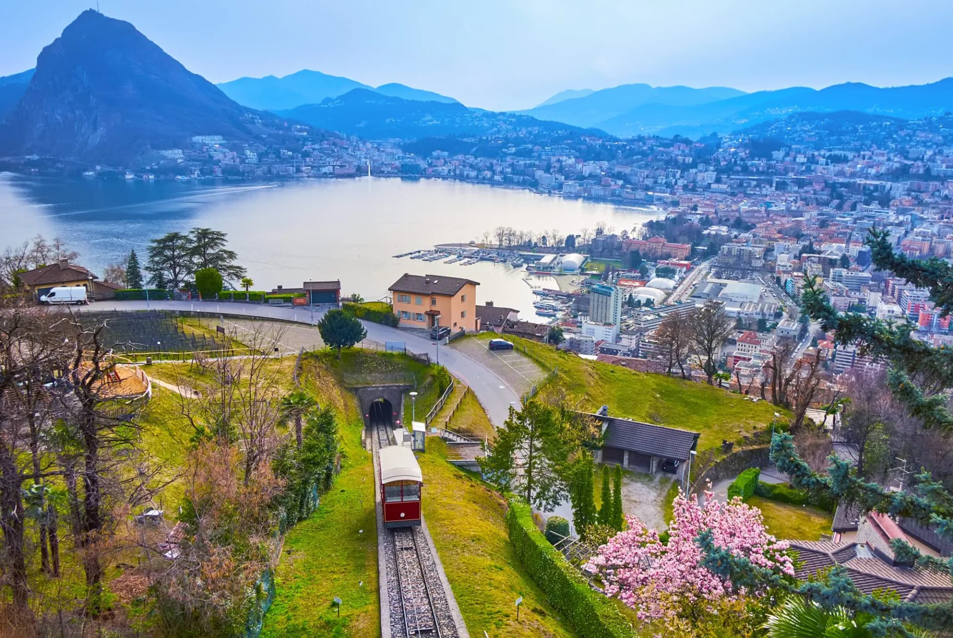 Monte San Salvatore funicular approaching tunnel above Lake Lugano and city, Switzerland.