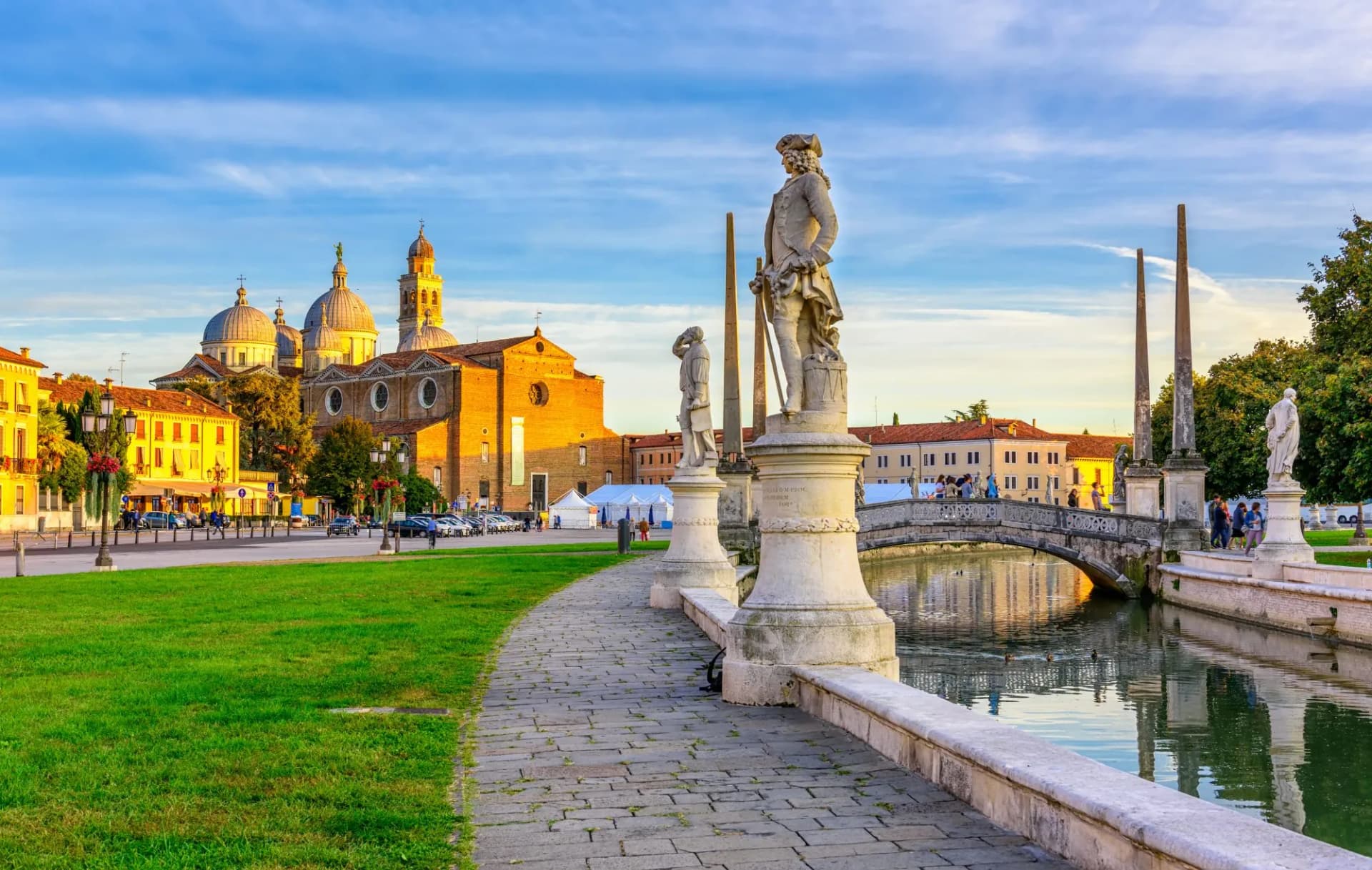 Statues line canal path near Basilica Santa Giustina in Prato della Valle, Padova, Italy.