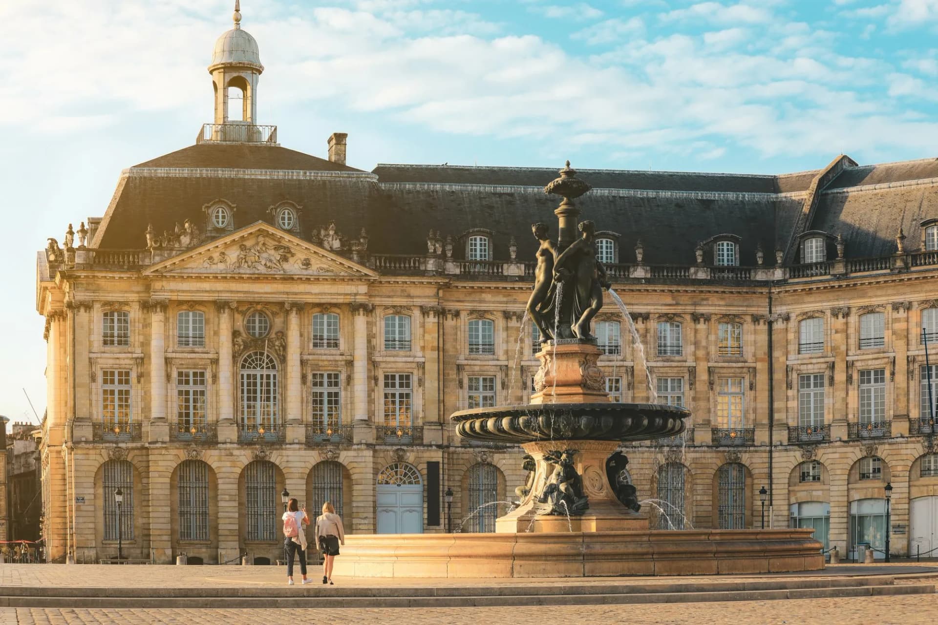 Three Graces Fountain in Place de la Bourse, classical French architecture in Bordeaux.