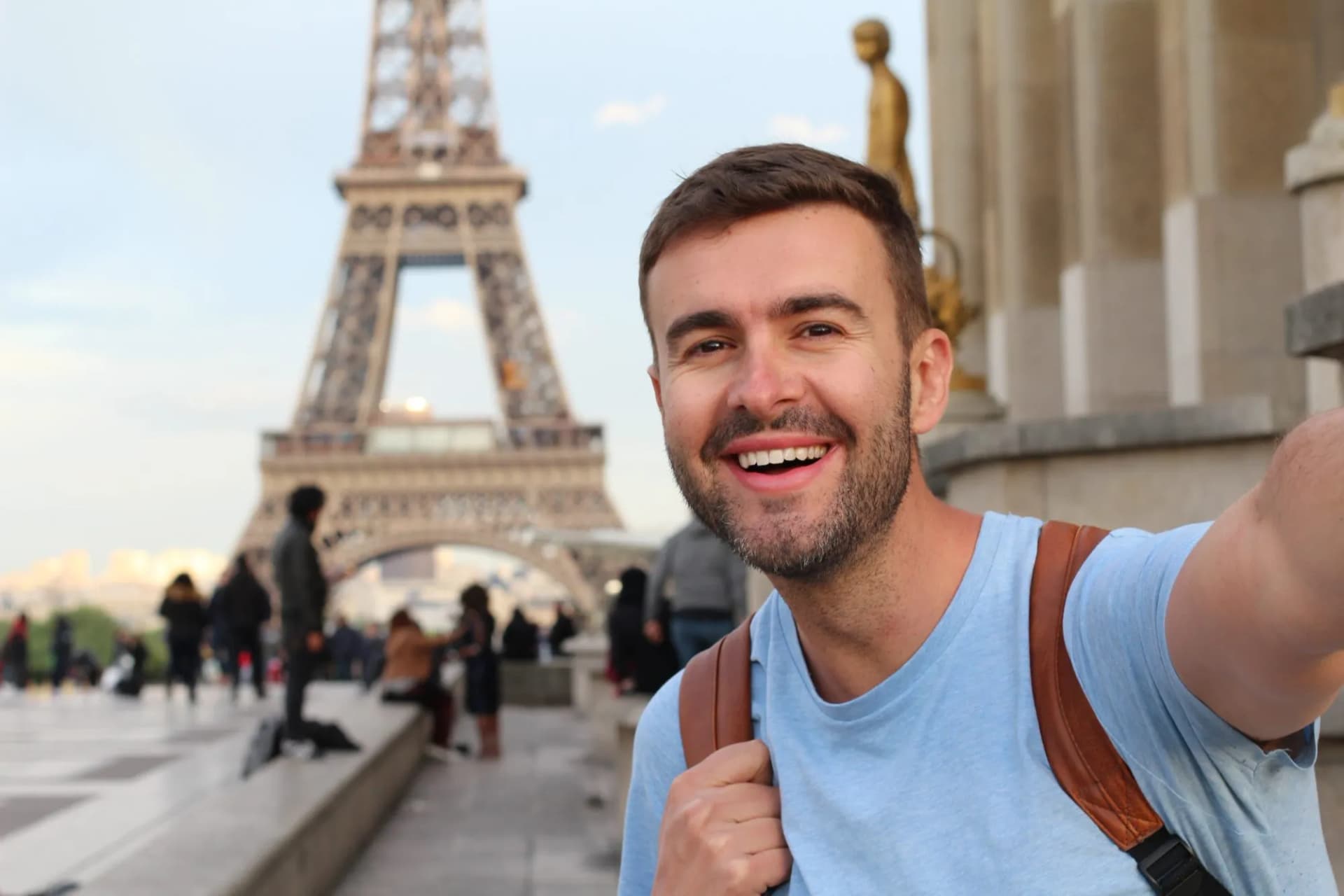 Man taking a selfie with the Eiffel Tower in Paris in the background