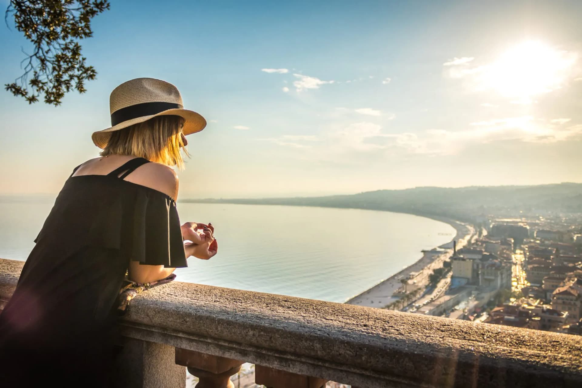 Woman with straw hat viewing Nice coastline and Mediterranean Sea from Castle Hill viewpoint.