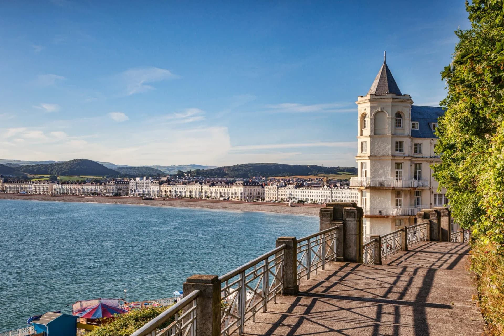 Promenade view of Llandudno seafront, The Grand Hotel, and hills in Conwy, Wales, UK.