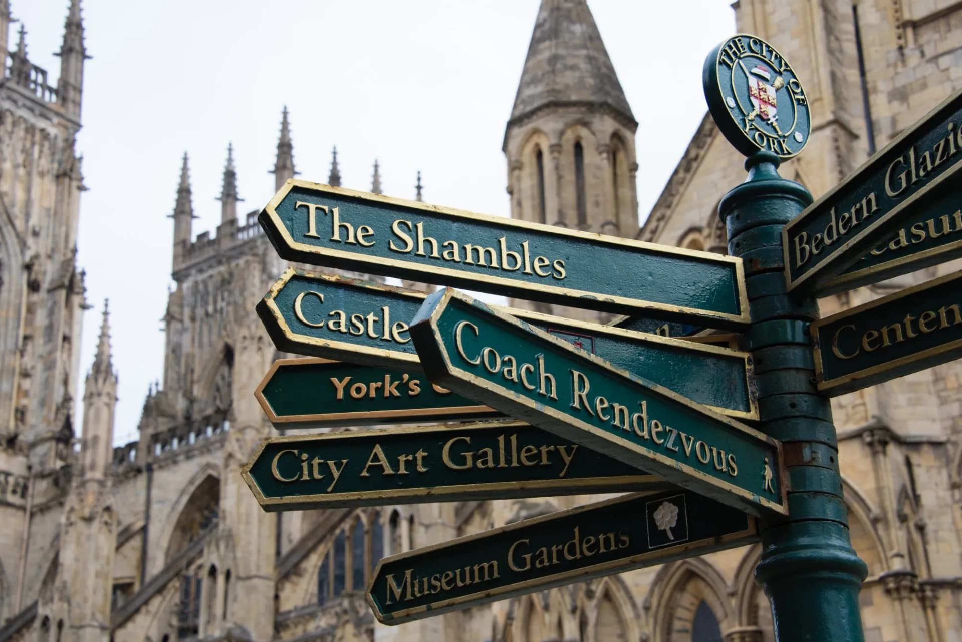 Direction signpost pointing to The Shambles, Castle, and City Art Gallery near York Minster.