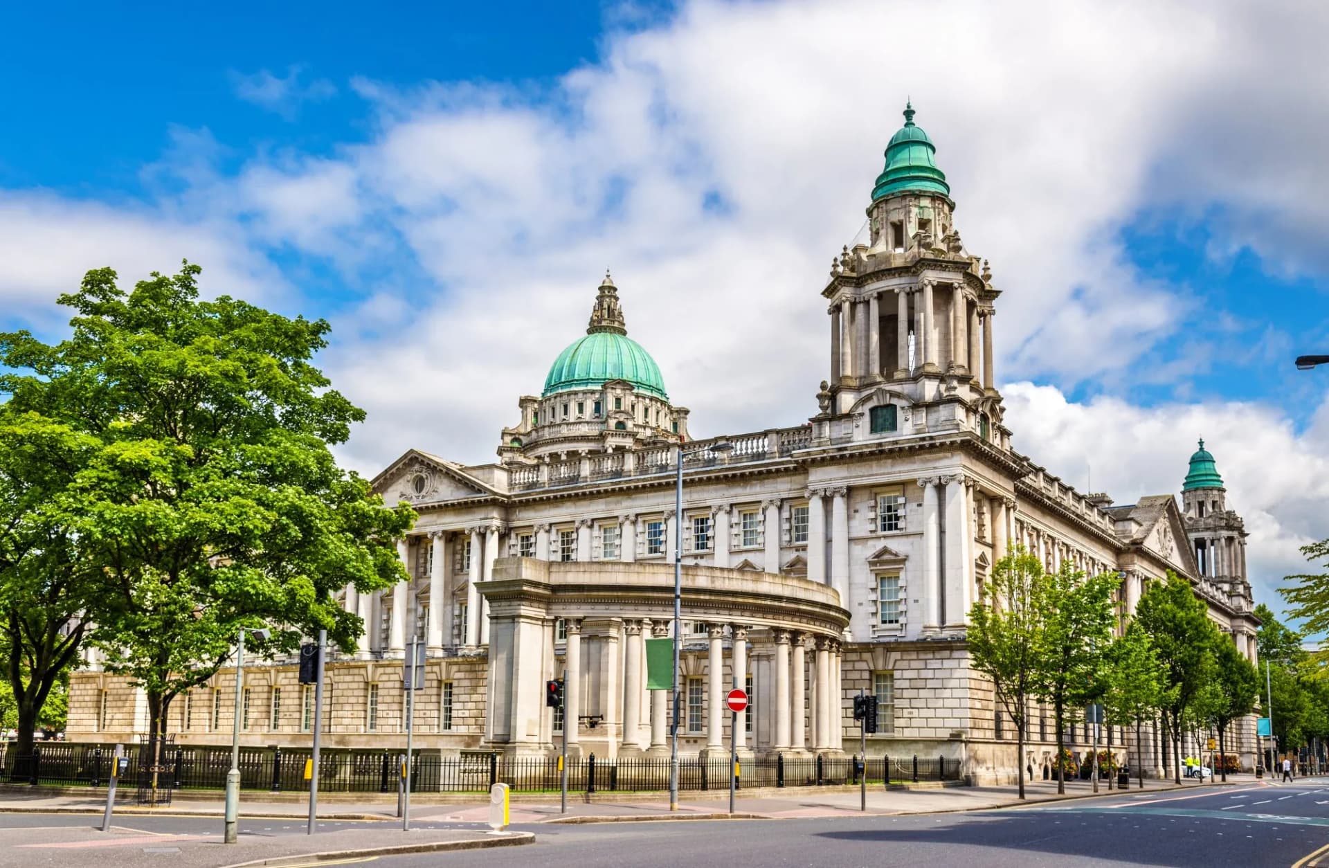Belfast City Hall, Northern Ireland, United Kingdom, with green domes under a blue sky.