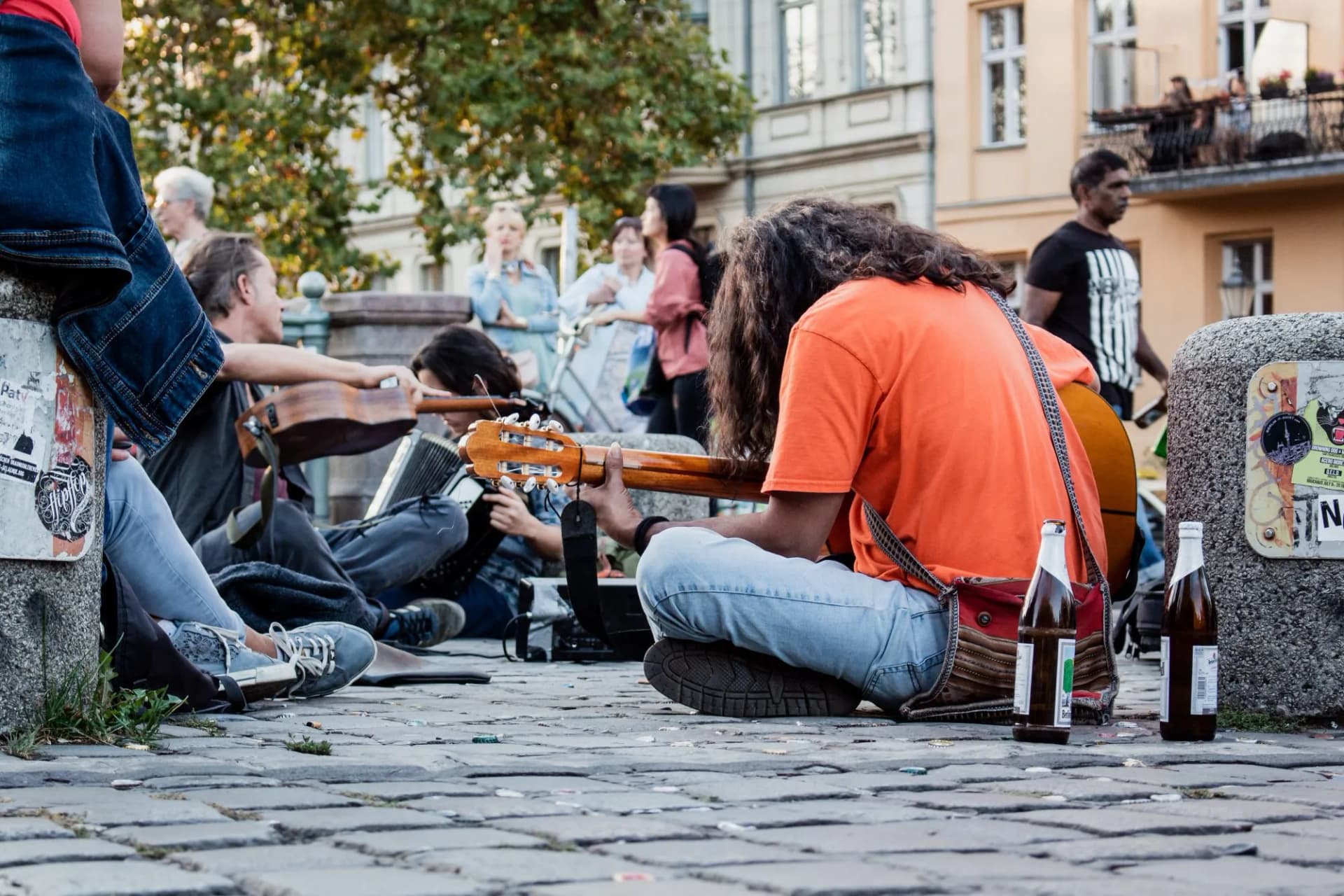 Musicians busking with guitar and accordion on cobblestone street in city square
