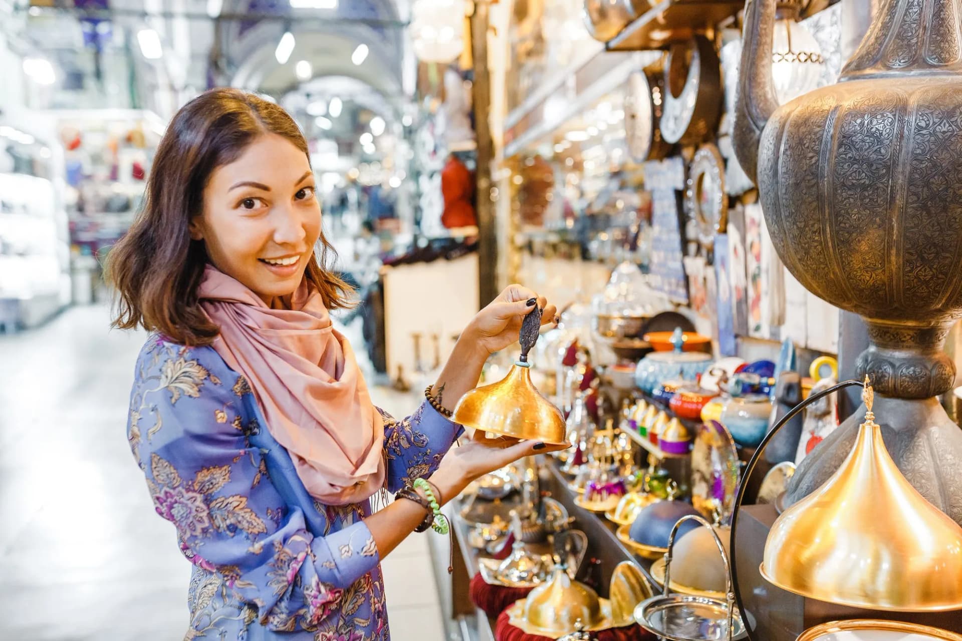 Woman shopping for brassware among countless shops in the Grand Bazaar Market in Istanbul, Turkey.