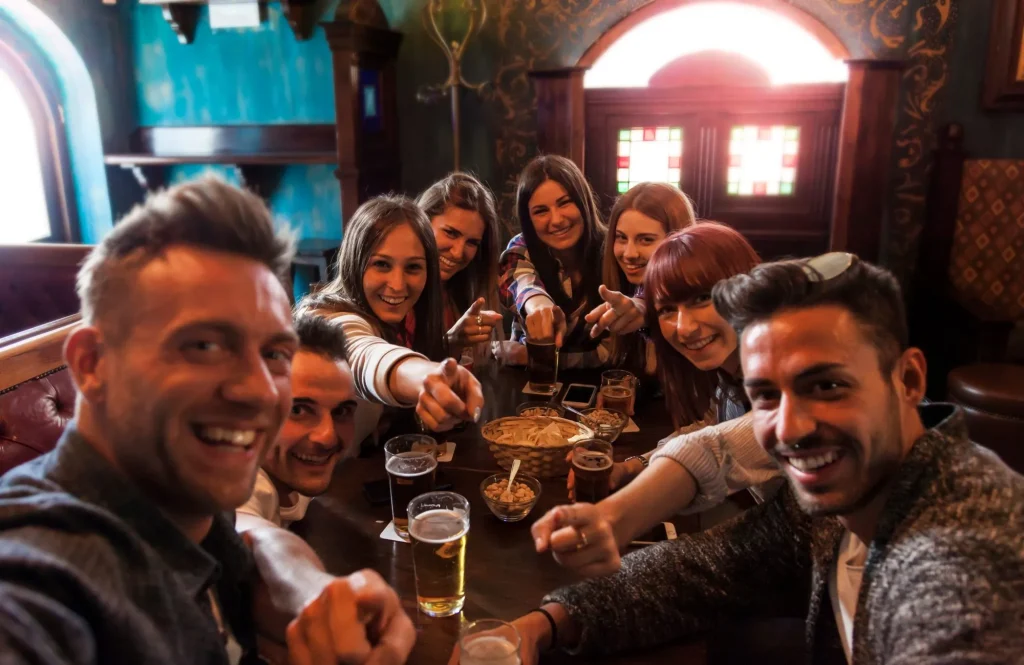 Gruppe von Menschen, die in einer Kneipe feiern und Bier trinken